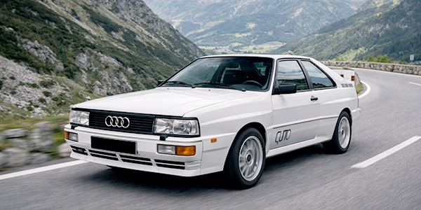 Audi Quattro aus den 80er-Jahren auf einer Bergstraße – legendärer Allrad-Oldtimer, der den Rallyesport und sportliche Gebrauchtwagen aus Österreich geprägt hat.