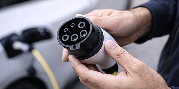 Sichtprüfung eines Ladekabels vor dem Laden eines Elektroautos.