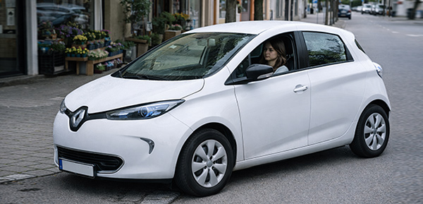 Kompaktes Elektroauto wird von junger Fahrerin in urbaner Umgebung genutzt.
