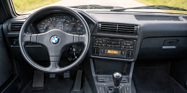 Cockpit eines 80er-Jahre-Oldtimers mit analogen Instrumenten und Kassettenradio als damaliges Symbol für Technik, Innovation und Fahrspaß des Jahrzehnts.