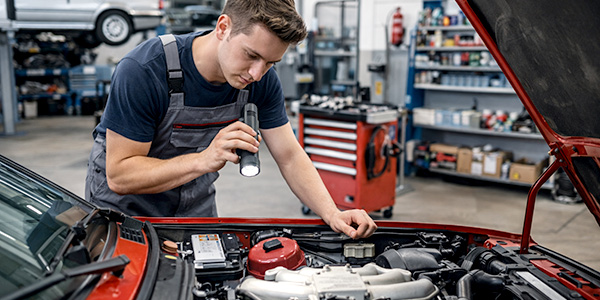 Mechaniker in einer österreichischen Oldtimer-Werkstatt bei der Restaurierung eines 80er-Jahre-Klassikers – Technikcheck, Wartung und Ersatzteile für zuverlässige Oldtimer.