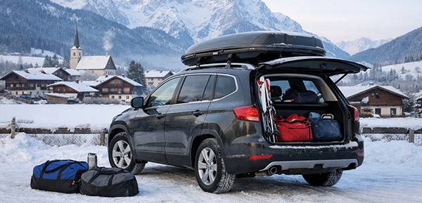 Familienauto für den Winterurlaub mit Dachbox in österreichischem Alpenort.